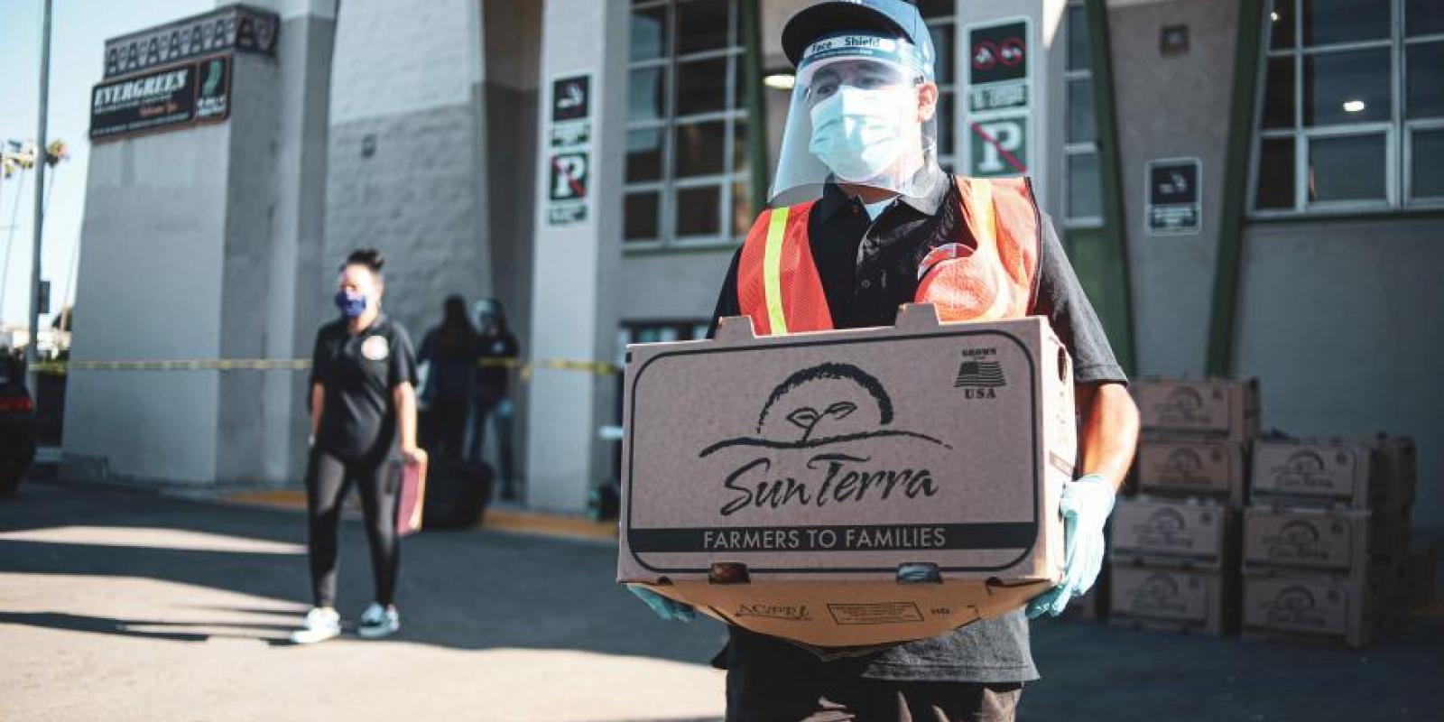 carrying a crate of oranges